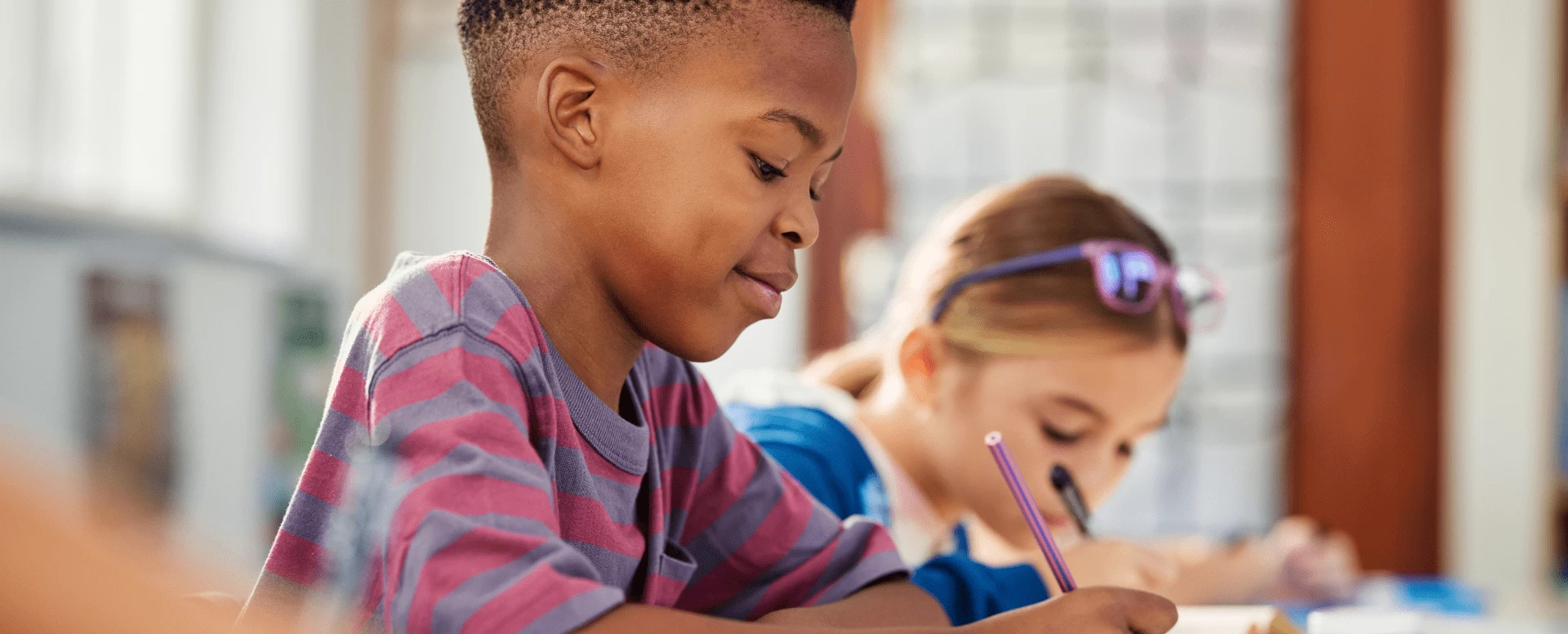 Crança concentrada em uma atividade escolar